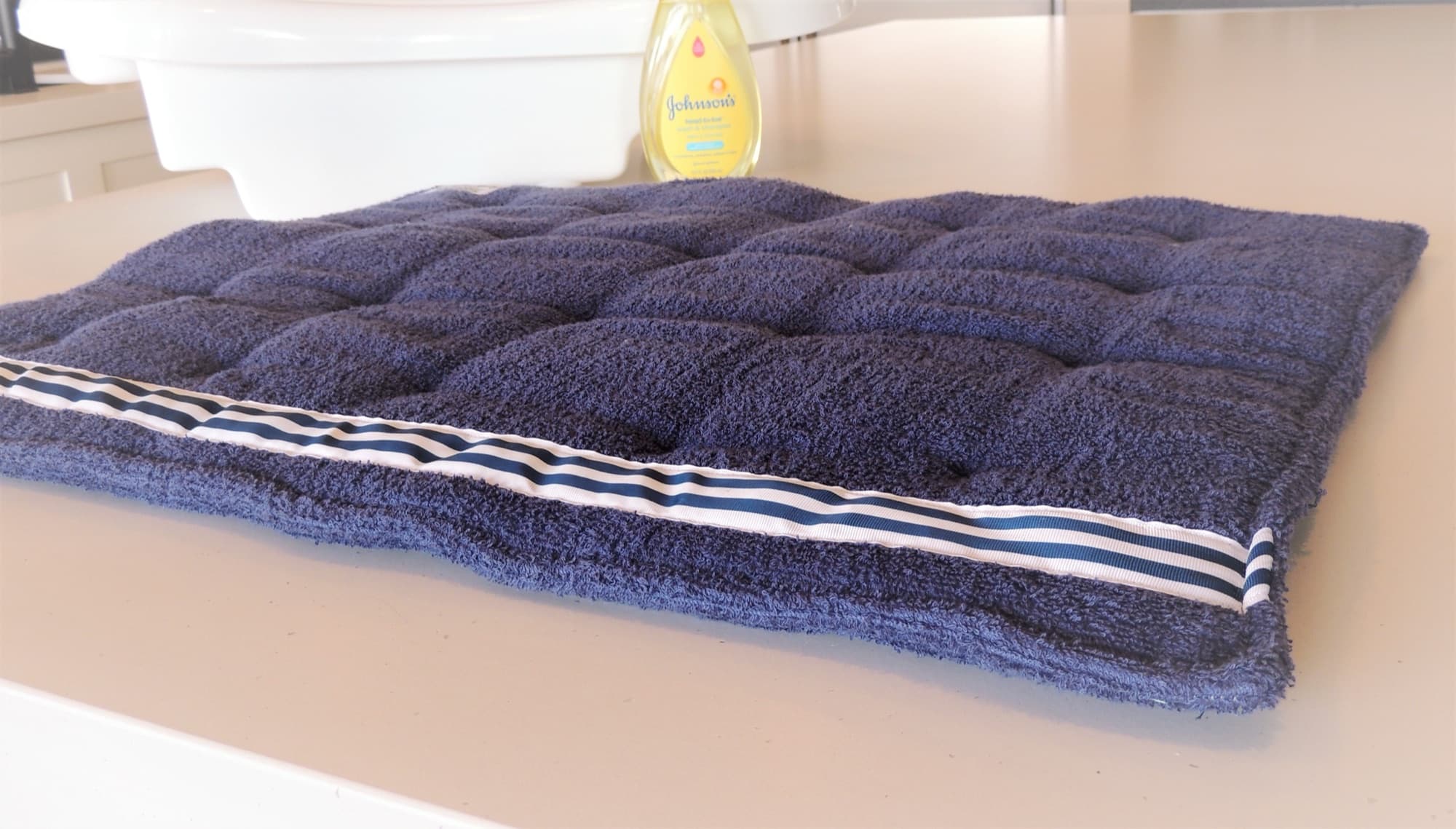 Close view of the quilted navy terry and striped ribbon trim